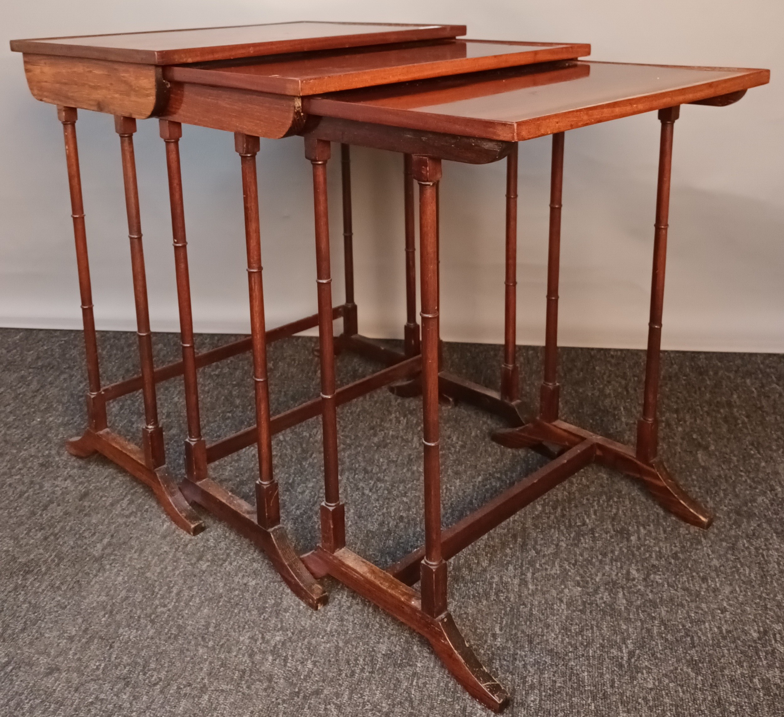 Antique nest of three tables, the surface with parquetry inlay and raised on trestle supports[