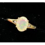10ct yellow gold ladies ring set with a single opalescent style stone off set by diamond