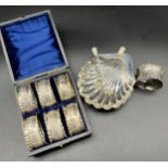 A Boxed set of six Sheffield silver napkin rings, Sheffield silver scallop shell dish designed