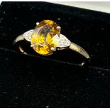 10ct yellow gold ladies ring set with a large oval cut orange/ yellow tourmaline stone off set by