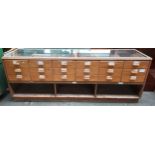 Retro haberdashery shop counter, glazed top and sides above banks of drawers and underneath interior