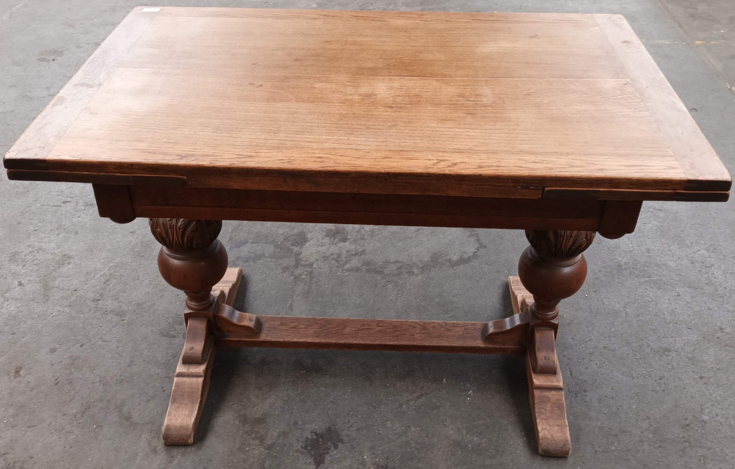Antique oak extending dining table, the rectangular surface raised by carved acorn design columns