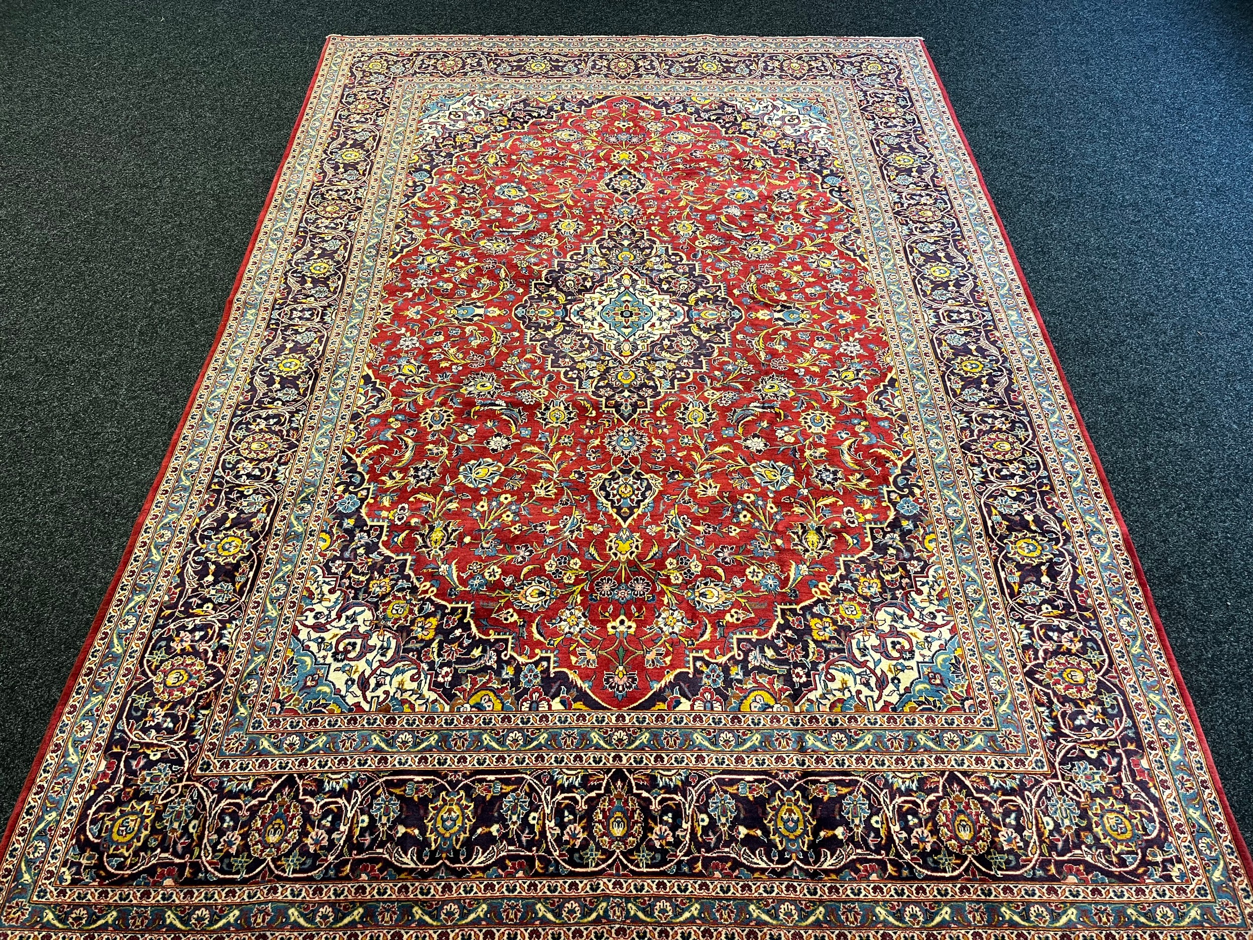 Large Persian carpet/rug, highly decorative with red ground. [535x296cm]