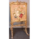 Regency moulded gilt frame fire screen, fitted with floral embroidery, raised on trestle supports [