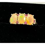 10ct yellow gold ladies ring set with three opalescent style stones off set by pink Iolite