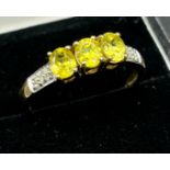 9ct yellow gold ladies ring set with three green tourmaline stones off set with diamond