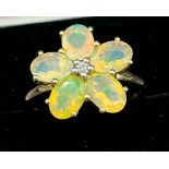 10ct yellow gold and opalescent style stone ring. Set as a flower with a single diamond to the
