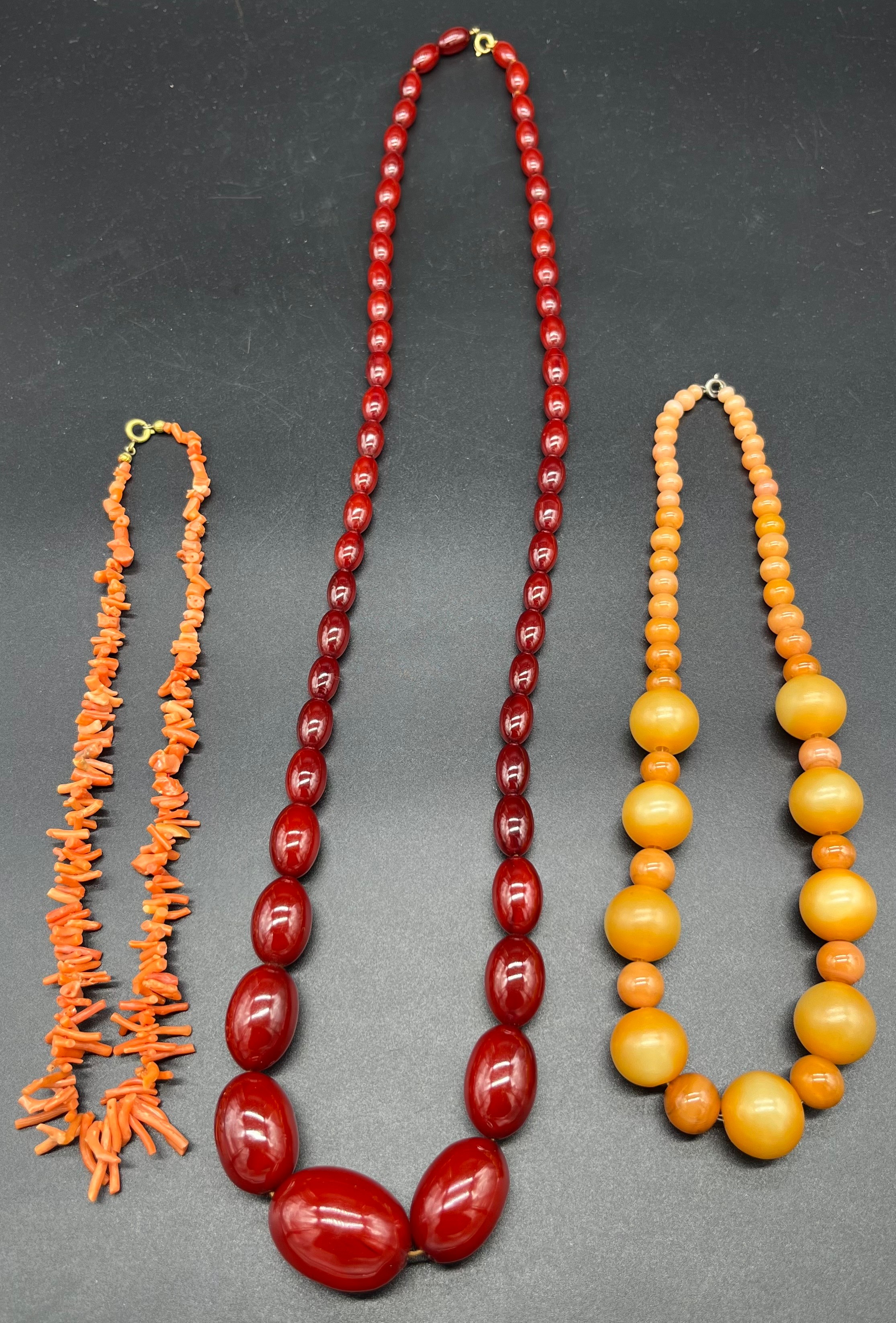 Three vintage necklaces to include coral necklace, glass ball effect necklace and cherry amber style