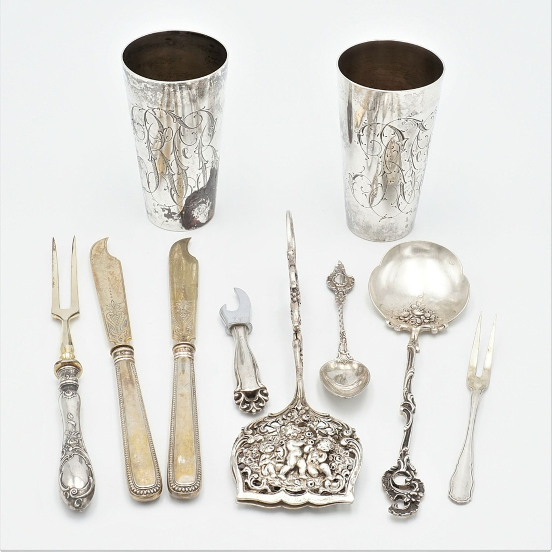 Two mugs and eight pieces of serving cutlery