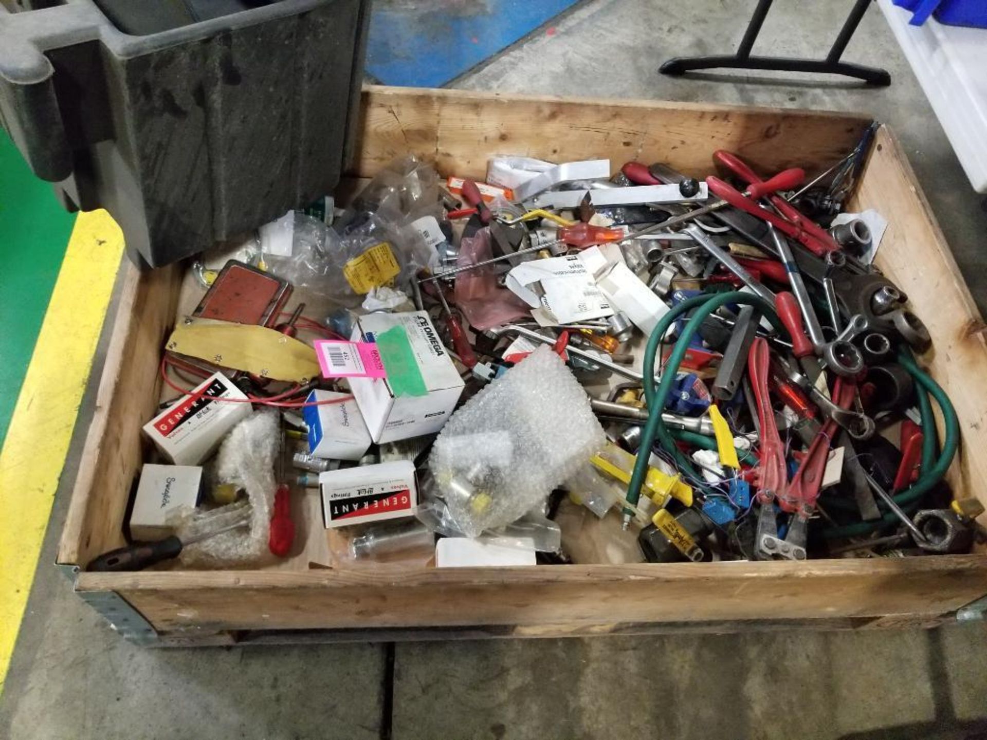Crate of assorted hand tools and replacement parts.