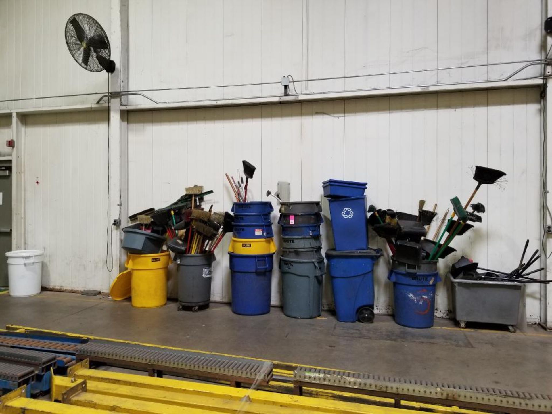 Large qty of trash cans and brooms.