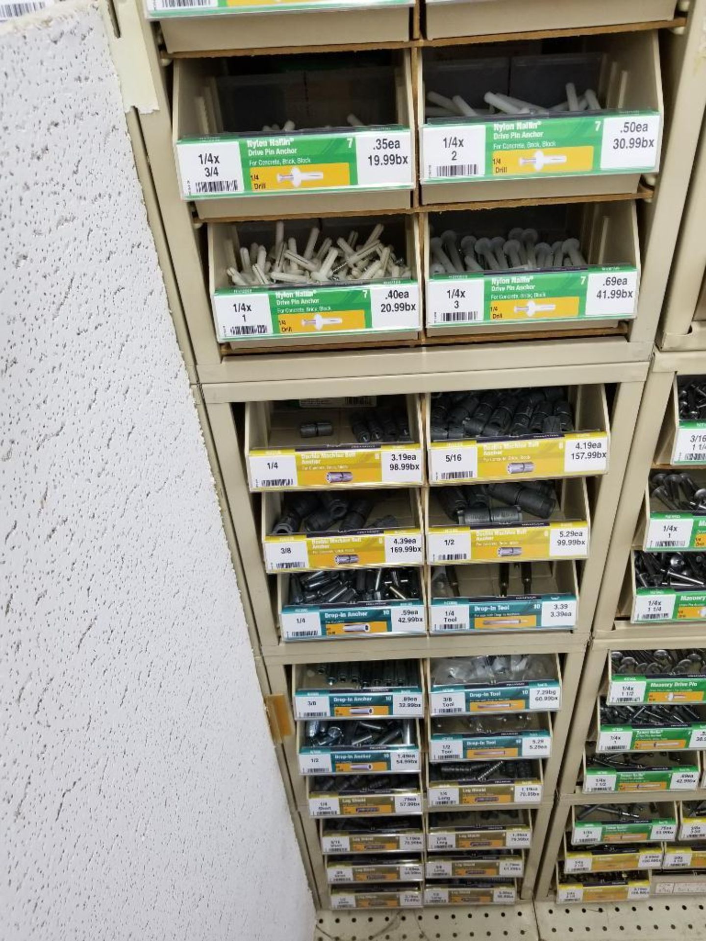 Full column section of bolt fastener display with bins, contents in bins and on top.