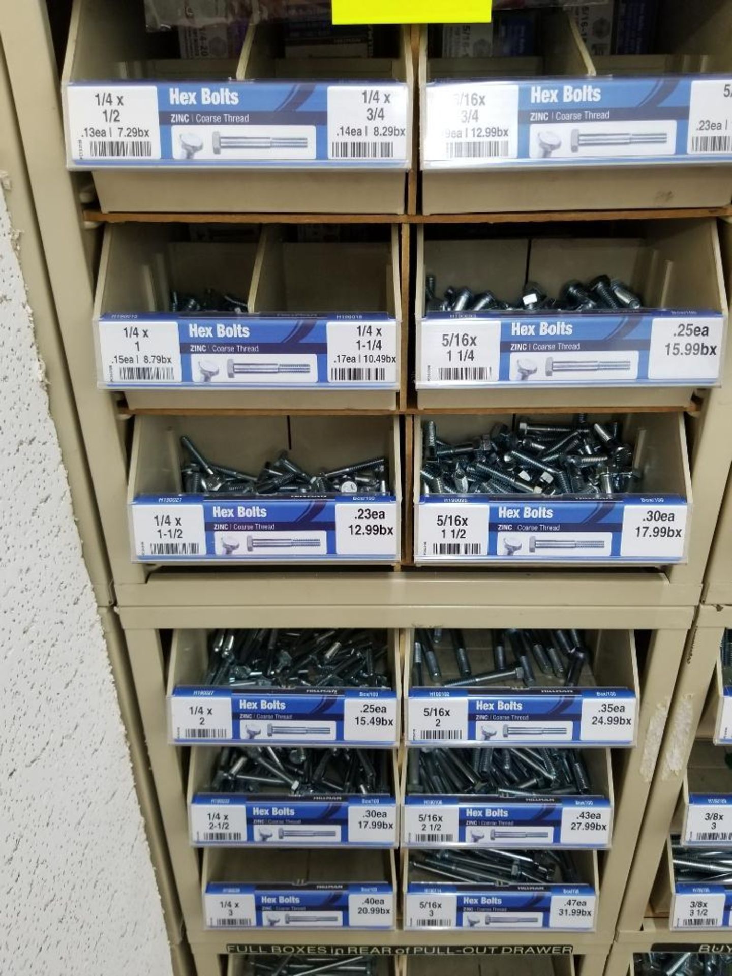 Full column section of bolt fastener display with bins, contents in bins and on top.