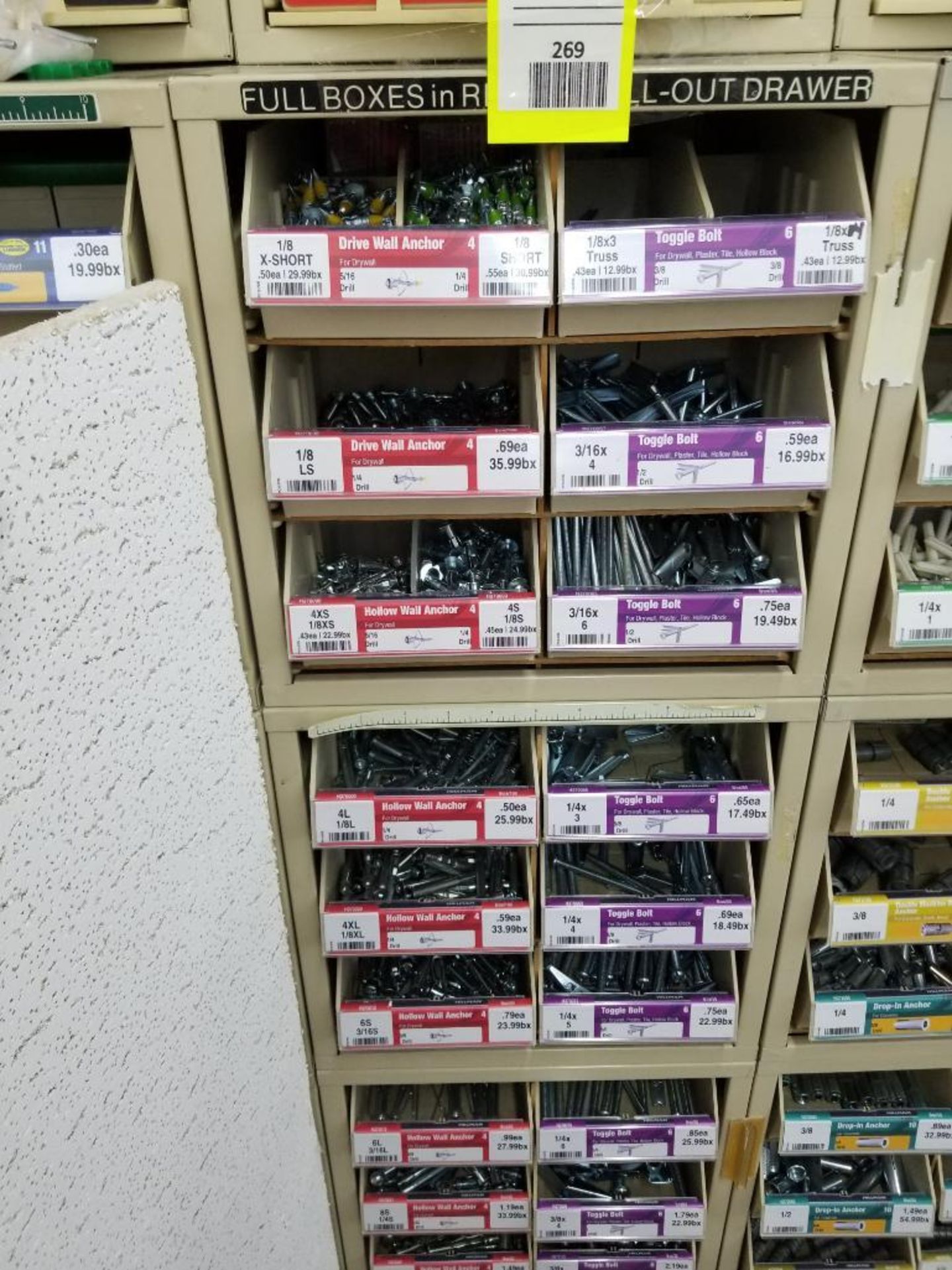 Full column section of bolt fastener display with bins, contents in bins and on top.