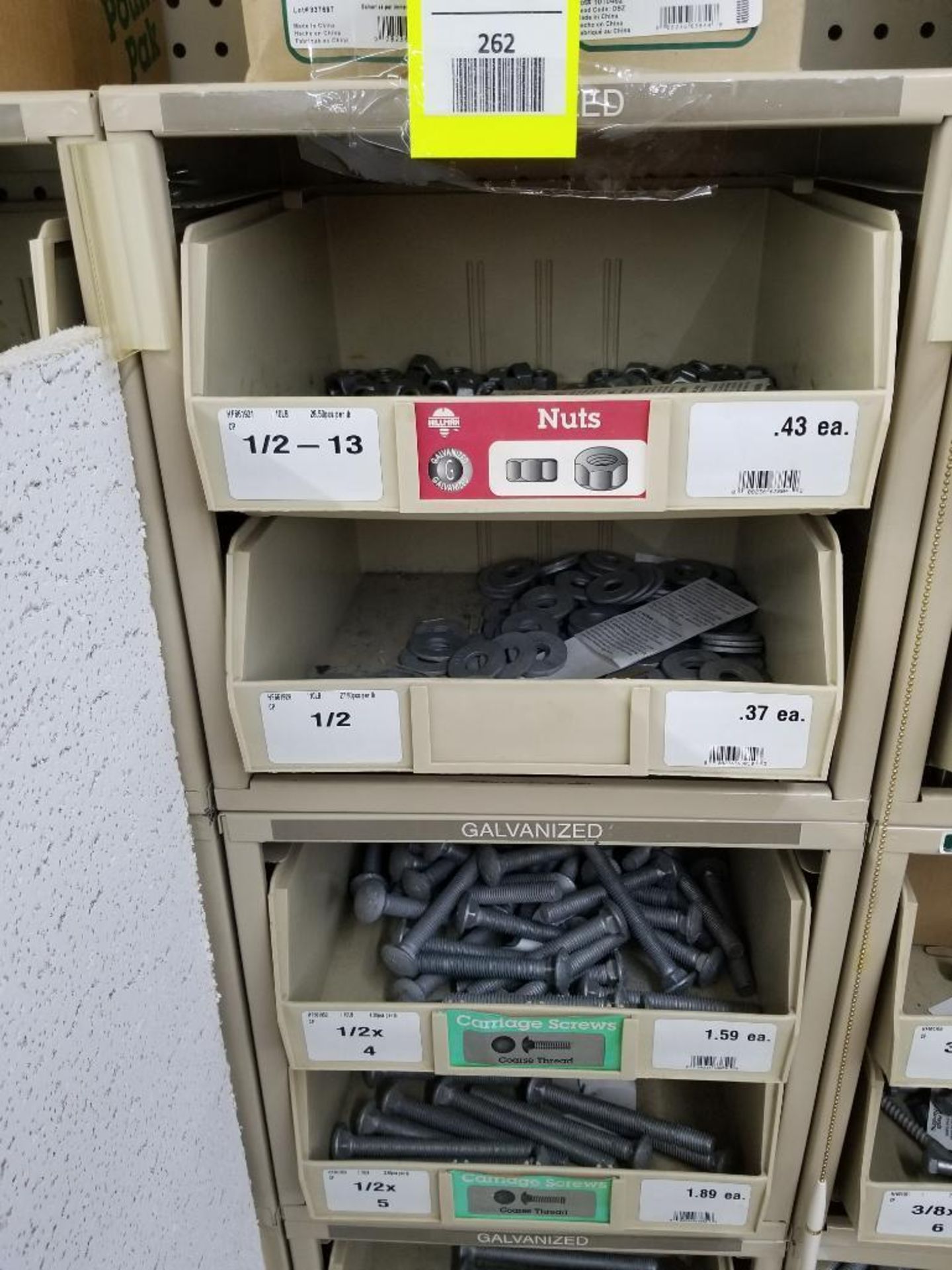Full column section of bolt fastener display with bins and contents in bins and on top.
