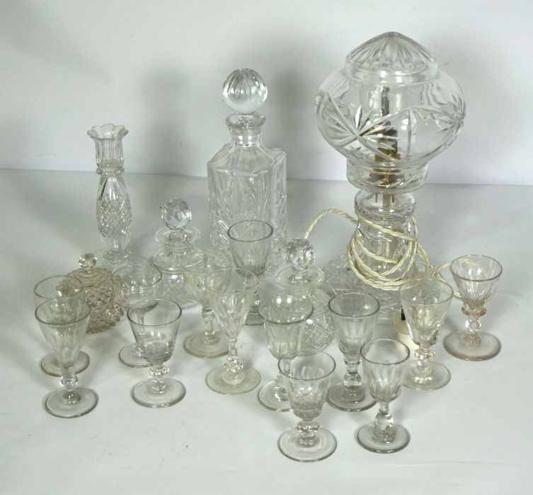 An assortment of table glassware, including a crystal glass covered table lamp, a candlestick,