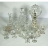 An assortment of table glassware, including a crystal glass covered table lamp, a candlestick,