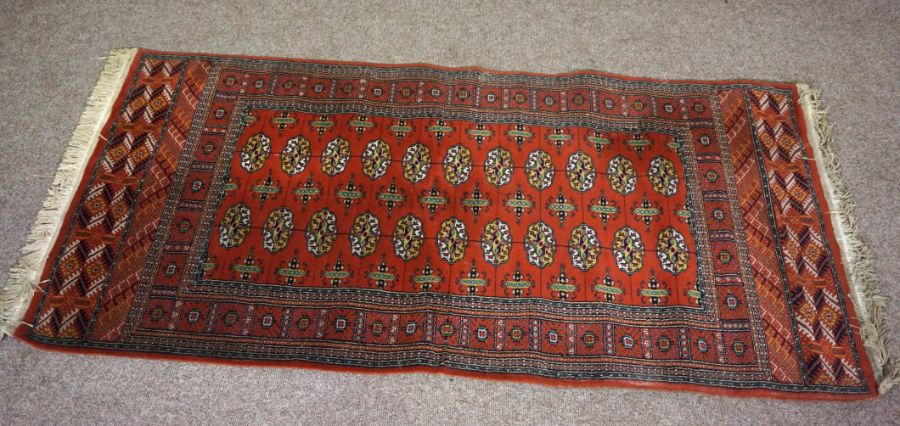 A small modern Tekke style rug, 20th century, with multiple medallions on a madder field within - Image 2 of 4