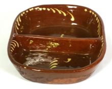 A slipware double sided baking dish, probably Welsh, 19th century, of oval form, with brown glaze