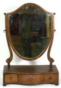 A Regency mahogany toilet mirror, early 19th century, with a shield framed mirror over a three