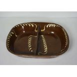 A large slipware double sided baking dish, probably Welsh, 19th century, of oval form, with brown