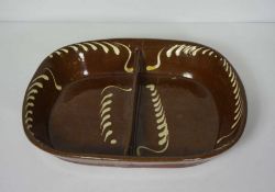 A large slipware double sided baking dish, probably Welsh, 19th century, of oval form, with brown