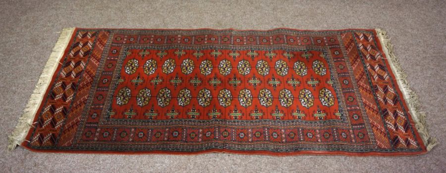 A small modern Tekke style rug, 20th century, with multiple medallions on a madder field within