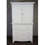 A white painted linen press style TV cabinet, modern, with two cabinet doors over three graduated