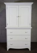 A white painted linen press style TV cabinet, modern, with two cabinet doors over three graduated