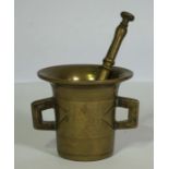 A brass mortar & pestle, the mortar of flared form with side handles, 10cm high, 13cm wide (2)