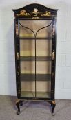 A japanned china cabinet, 20th century, with an arched top, glazed cabinet door opening to