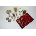 A small assortment of silver, including a dressing set, cased coffee spoons, sugar nips and small