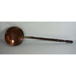 A copper warming pan, 19th century, with turned wooden handle