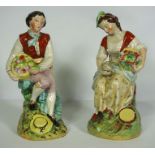 A pair of Staffordshire pottery figures of a Lady and Gallant, mid 19th century, each holding a