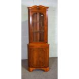 A modern yew wood veneered corner cabinet, 187cm high, 65cm wide