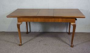 A George II style walnut veneered extending dining table, 20th century reproduction, with one