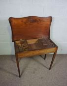 A late George III mahogany dressing table, circa 1800, of serpentine form, the folding top opening