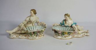 A pair of Staffordshire china sweetmeat baskets, each supported by a reclining figure, 19th century,