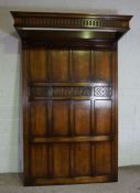 A large Jacobean style oak panelled half tester styled bedhead, 20th century, with carved and