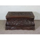A Chinese carved hardwood chest, early to mid 20th century, the top and front deeply carved with