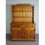 An oak dresser, modern, 20th century, the rack with two shelves over two drawers and two cabinets,