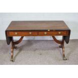 A Regency style mahogany and rosewood sofa table, 19th century, with a rounded drop leaf top,