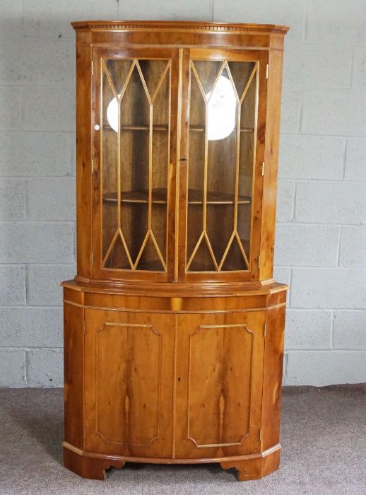 A modern yew wood veneered bow front corner cabinet, floor standing, 181cm high. 82cm wide