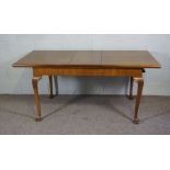 A George II style walnut veneered extending dining table, 20th century reproduction, with one