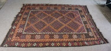 A Kilim rug, 20th century, with geometric lozenges on a brown field, 277cm long, 200cm wide
