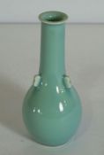 A Chinese porcelain monochrome vase, 20th century, with a light blue glaze, the body with three lugs