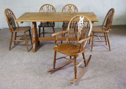 A small kitchen table, wheel backed chairs and a rocking chair.