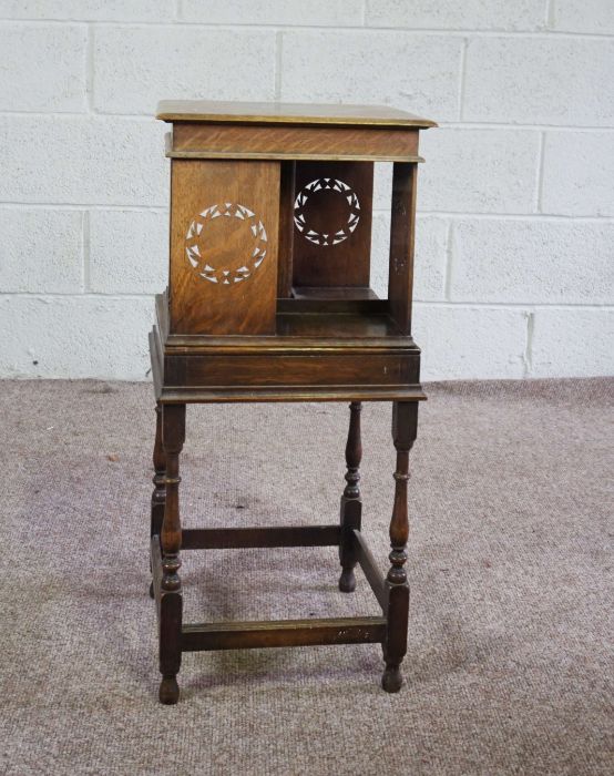 A rotating oak bookstand, circa 1900, with square moulded top, four book compartments with