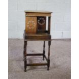 A rotating oak bookstand, circa 1900, with square moulded top, four book compartments with