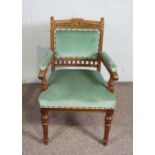 A late Victorian oak framed armchair, circa 1900, the crest rail carved with a bird and foliate